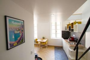 eine Küche mit einem Waschbecken und einem Tisch in einem Zimmer in der Unterkunft LOFT LE BER'AMAR L'ESTAQUE in Marseille
