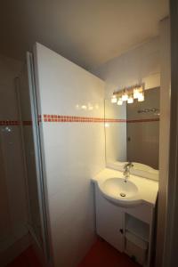 a white bathroom with a sink and a mirror at Archipel Accueil International - Studio Bois des Coqs in Saint-Chaffrey