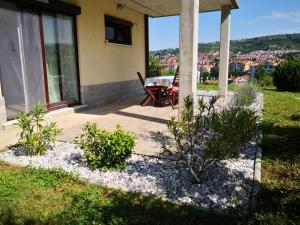 a patio of a house with a table and chairs at Solmar, Apartment with big terrace near nature in Portorož