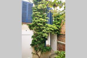 a building with blue shutters and a white door at Joli appartement à 2 pas de Paris in Bagnolet