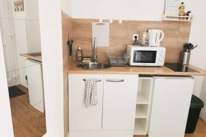 a small kitchen with a sink and a microwave at Joli appartement à 2 pas de Paris in Bagnolet