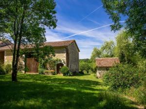 an old stone barn in a yard with a tree at G te near Saint Emilion in Saint-Martin-de-Gurçon