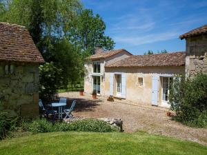 a cottage with a table and chairs in a yard at G te near Saint Emilion in Saint-Martin-de-Gurçon