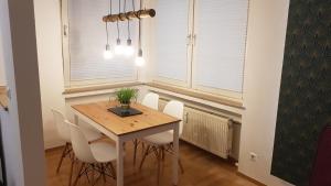 a dining room with a wooden table and white chairs at FeWo -Kleines Moselglück- in Winningen bei Koblenz in Winningen