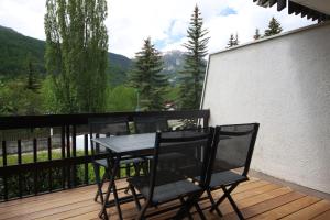 a table and chairs on a deck with a view at Archipel Accueil International - Studio Bois des Coqs in Saint-Chaffrey