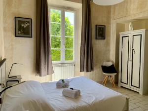 イエールにあるLe château des Angladesのベッドルーム1室(ベッド1台、タオル2枚付)