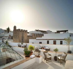 uma varanda com cadeiras e uma mesa num edifício em Plaza 18 em Vejer de la Frontera