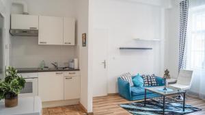 Il comprend une cuisine et un salon avec un canapé bleu. dans l'établissement Gorgeous 2BR - Spacious & Suitable for Everyone, à Vienne