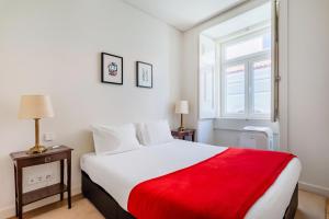 - une chambre avec un grand lit et une couverture rouge dans l'établissement Chiado Prime Garrett Apartment, à Lisbonne