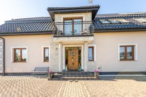 ein Haus mit einer Bank davor in der Unterkunft Villa Konwalia in Grzybowo
