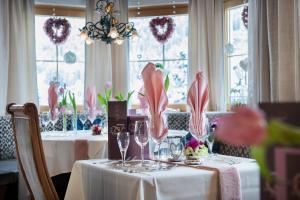 una sala da pranzo con due tavoli e bicchieri da vino di Wohlfühlhotel Innertalerhof a Gerlos