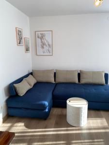 a blue couch sitting in a living room at Neringarent Apartamentai in Juodkrantė