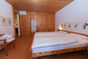 una camera con due letti in una stanza con pareti in legno di Schweizerhof Drescher a Lenzerheide