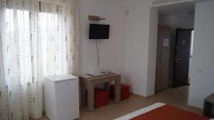 a living room with a small table and a television at HOTEL BOURBON Vama Veche in Vama Veche