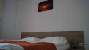 a bed with two pillows and a picture on the wall at HOTEL BOURBON Vama Veche in Vama Veche +10 photos