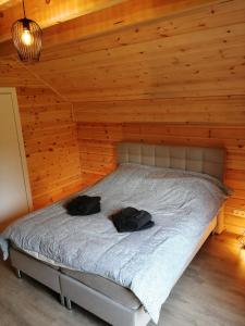 een slaapkamer met een bed in een houten kamer bij Chalet Sarah in Durbuy