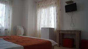 a bedroom with a bed and a television on the wall at HOTEL BOURBON Vama Veche in Vama Veche