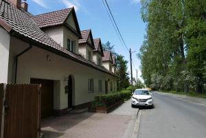 Apartament Parkowy في كراكوف: سيارة متوقفة على رصيف بجانب منزل