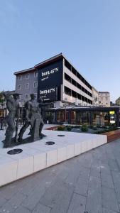 a building with a sculpture in front of it at Boutique Hotel Bura 45N in Senj