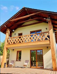 a house with two chairs in front of it at Zacisze pod Śnieżką in Mysłakowice