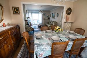 een eetkamer met een tafel met stoelen en een eetkamer bij La Mouette in Cancale