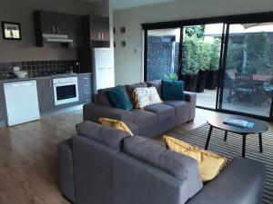 a living room with two couches and a kitchen at Adelphi Apartment 2- Poolside or Apartment 2A- King Studio in Echuca
