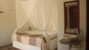 um quarto com uma cama com um lavatório e um espelho em Eco Kite Dunas em Praia do Preá