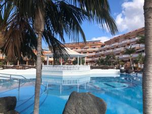 a swimming pool with a hotel in the background at Apartamento Las Vistas Beach - Tenerife Royal Gardens in Playa de las Americas