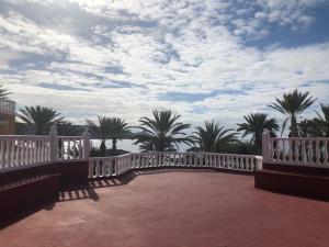 a white bridge with palm trees and a cloudy sky at Apartamento Las Vistas Beach - Tenerife Royal Gardens in Playa de las Americas