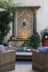 Il Cortile di Elisa & our flats في لوكّا: نافورة حجرية في حديقة بها زهور ونباتات