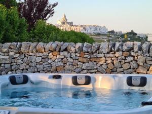 a hot tub with a stone retaining wall at Trulli Nannì in Locorotondo