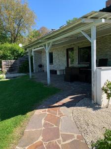 a house with a stone walkway leading to a patio at Die Panorama-Wohnung-im-Grünem in Allensbach