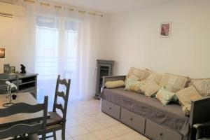 ein Wohnzimmer mit einem Sofa und einem Tisch in der Unterkunft Confortable 3 pièces très bien placé centre ville in Antibes
