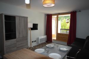a living room with a table and a window at Archipel Accueil International - Studio Bois des Coqs in Saint-Chaffrey