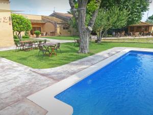 a swimming pool in a yard with a table and chairs at Hotel & Golf Ca La Caputxeta - Adults Only in Roses