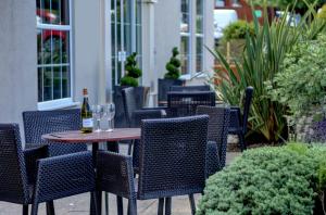 un tavolo con bicchieri e una bottiglia di vino di Best Western Premier EMA Yew Lodge Hotel a Castle Donington