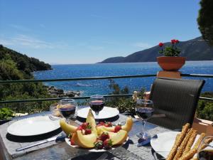 a table with a plate of bananas and glasses of wine at Ilios studios in Vasiliki
