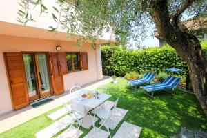 a backyard with a table and chairs and a tree at Maison Olive in Desenzano del Garda