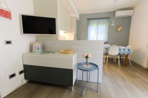 a living room with a table and a tv on a wall at Maison Olive in Desenzano del Garda