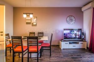 una sala da pranzo con tavolo, sedie e TV di Rooftop Penthouse - Private Hottub & Duplex Whirlpool a Makarska