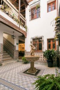 a fountain in the middle of a courtyard with a building at Casa Museo La Merced in Málaga