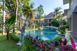 a swimming pool in front of a house with a garden at The Gantari Ubud Hotel & Villa in Ubud
