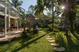 a garden with stepping stones on the grass at The Gantari Ubud Hotel & Villa in Ubud
