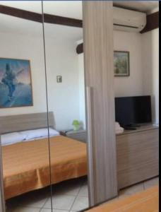 sypialnia z łóżkiem i lustrem w obiekcie Casa vacanze Mamma Rosa w mieście Canale Monterano