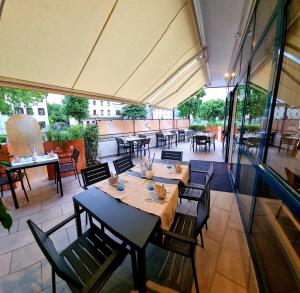 a restaurant with a table and chairs and a patio at Hotel Mirella e Ristorante Bar Don Bacco in Orsago