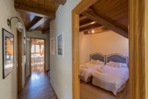 a bedroom with two beds in a room with wooden ceilings at Tensina ❅ Acogedor salón y gran terraza privada ❀ in Sallent de Gállego