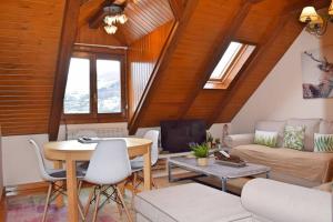 a living room with a table and a couch at Tensina ❅ Acogedor salón y gran terraza privada ❀ in Sallent de Gállego