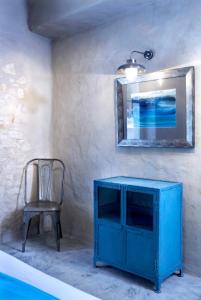 un armario azul y una silla en una habitación en To Throni, en Tselendáta