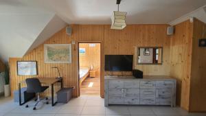 una sala de estar con escritorio y TV y una habitación con sofá en Apartament Antałówka !, en Zakopane