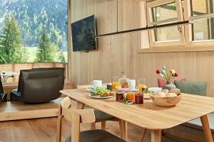a dining room with a table with food on it at Spycher - Chalets für 2 in Riezlern